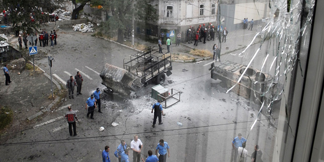 Police gather near a burned armored military vehicle and truck belonging to the self-proclaimed 