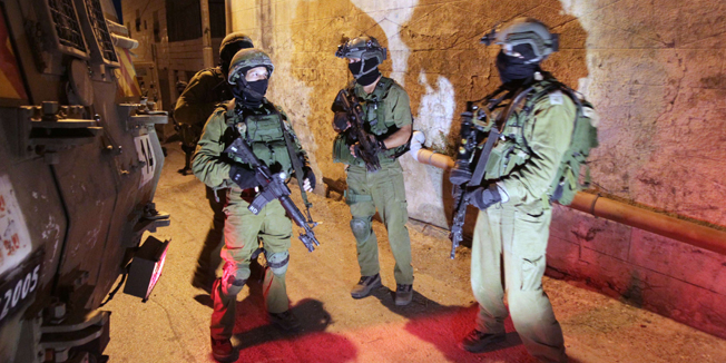 Israeli soldiers patrol an area in the West Bank town of Hebron on June 15, 2014, as they search for three teenagers who went missing near a West Bank settlement. The youngsters, one of whom also holds a US passport, are believed to have been snatched on June 12, 2014 from the Gush Etzion settlement bloc between Bethlehem and Hebron, reportedly while hitchhiking. Israel holds the Palestinian Authority responsible for the safe return of the three teenagers kidnapped by a 