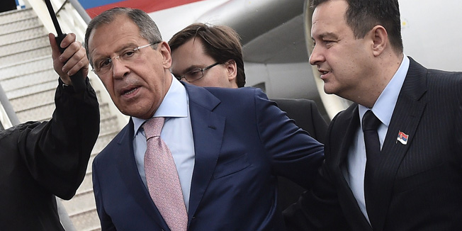 Serbian Foreign Minister Ivica Dacic (R) and his Russian counterpart Sergei Lavrov (C) address to the journalists at Belgrade's airport on June 16, 2014, upon Lavrov's arrival to Serbia on a two day official visit.  AFP PHOTO / ANDREJ ISAKOVIC