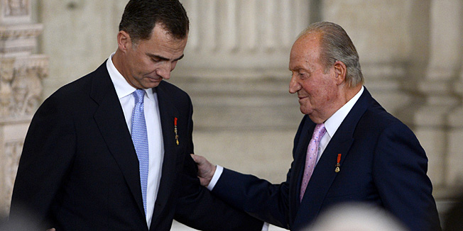 Former Spanish King Juan Carlos congratules Spain's Prince Felipe VI (R) during the ceremony of approval and enactment of a law bringing into effect King Juan Carlo's abdication in the Columns Hall at the Royal Palace in Madrid on June 18, 2014. Spanish King Juan Carlos announced his abdication on June 2, 2014 in favour of his son Prince Felipe who tomorrow will swear an oath infront of both houses of parliament, ending a 39-year reign that guided Spain from dictatorship to democracy but was later battered by royal scandals. AFP PHOTO / GERARD JULIEN