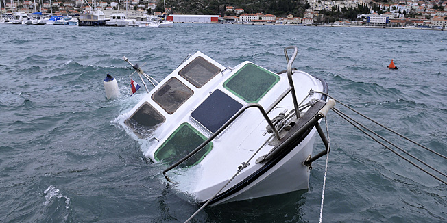 Dubrovnik, 060112.Udari bure na dubrovackom podrucju jutros dosezali su snagu od preko 100 km na sat zbog cega je doslo do loma vise stabala te zakrcenja prometnica, ali i ostecenja vozila. Na Lapadskoj obali su potonule dvije barke, a vjetar je prevrnuo i jednu barku koja se nalazila na suhom vezu na obali. Na slici: potopljena barka.Foto: Tonci Plazibat / CROPIX