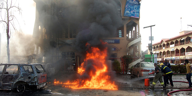 Fire fighters try to put out a fire after a bomb exploded in a crowded shopping centre in Nigeria's capital Abuja on June 25, 2014. A bomb exploded in a crowded shopping centre in Nigeria's capital Abuja, killing at least 21 people and wounding 17, police and the government said. AFP PHOTO / STRINGER