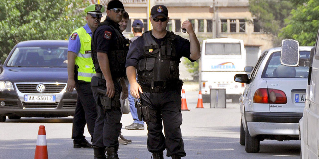 Albanian police forces control cars in the lawless marijuana-growing village of Lazarat, south of the capital Tirana, on June 16, 2014. Suspected drug traffickers fired heavy machine guns and rocket propelled grenades on June 16 at Albanian police attempting to enter a village renowned for its mass cannabis production, authorities said. Police said at least 500 officers tried to access Lazarat, 240 kilometres (150 miles) south of Tirana, in order to destroy the village's drug stockpile. The force came under heavy arms fire, including anti-tank rockets, it said. According to Italian police the village produces 900 tonnes of cannabis each year worth some 4.5 billion euros ($6.1 billion) -- equivalent to almost half of Albania's gross domestic product. AFP PHOTO / STRINGER