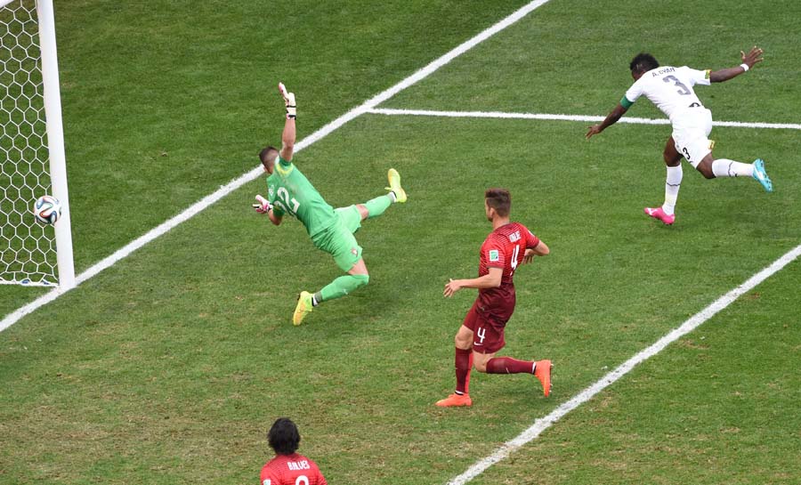 Ghana's forward and captain Asamoah Gyan (R) celebrates after scoring a goal as Portugal's goalkeeper Beto (C) fails to save the ball during the Group G football match between Portugal and Ghana at the Mane Garrincha National Stadium in Brasilia during the 2014 FIFA World Cup on June 26, 2014.  AFP PHOTO / EVARISTO SA