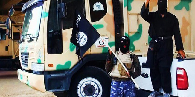 (FILES) - A file picture uploaded on June 14, 2014 on the jihadist website Welayat Salahuddin allegedly shows militants of the Islamic State of Iraq and the Levant (ISIL) standing next to captured vehicles left behind by Iraqi security forces at an unknown location in the Salaheddin province. For militant groups, the fight over public perception can be even more important than actual combat, turning military losses into propaganda victories and battlefield successes into powerful tools to build support for the cause. AFP PHOTO / HO / WELAYAT SALAHUDDIN=== RESTRICTED TO EDITORIAL USE - MANDATORY CREDIT 