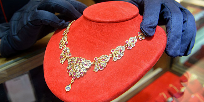 A salesperson displays a diamonds studded gold necklace at a shop in Singapore on April 18, 2013. Gold prices clawed back some losses on April 16 after suffering their heaviest slump in 30 years owing to weak Chinese growth data and reports that Cyprus was planning to sell some of its reserves of the precious metal. AFP PHOTO/ROSLAN RAHMAN