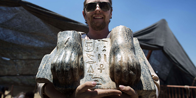 Australian excavation volunteer Joshua Talbot displays the remains of a Sphinx with a hieroglyphic inscription between its paws dating circa 3rd century BCE, found during excavation in the Northern Israeli archeological site of the ancient Tel Hazor, revealed on July 9 2013. The Sphinx was sculpted for Egyptian King Mycerinus, one of the builders of the Giza pyramids, and this is the first time ever a statue dedicated to Mycerinus has been uncovered, and the first time such a finding has been unearthed in the Levant.  AFP PHOTO/MENAHEM KAHANA