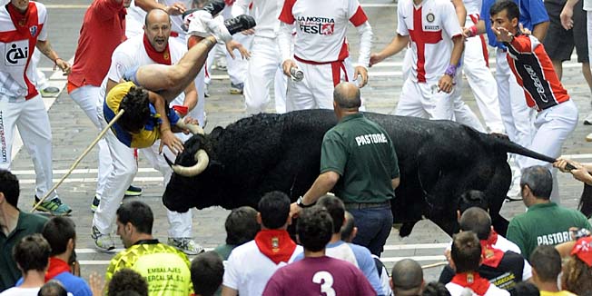 A participant is gored by a El Pilar's bull during the sixth bull run of the San Fermin Festival in Pamplona, northern Spain on July 12, 2013.   AFP PHOTO/ ANDER GILLENEA
