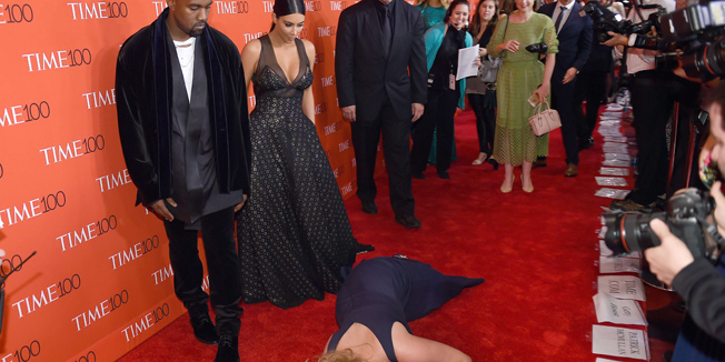 Honoree and Comedian Amy Schumer pretends to trip and fall on the floor  in front of honorees Kim Kardashian (2nd-L) and Kanye West (L) as they attend the Time 100 Gala celebrating the Time 100 issue of the Most Influential People at  The World at Jazz at Lincoln Center on April 21, 2015 in New York.  AFP PHOTO /  TIMOTHY  A. CLARY