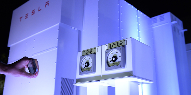 LOS ANGELES, CA - APRIL 30: A guests takes photographs of the Powerpack system after Elon Musk, CEO of Tesla unveiled suit of batteries for homes, businesses, and utilities at Tesla Design Studio April 30, 2015 in Hawthorne, California. Musk unveiled the home battery named Powerwall with a selling price of $3500 for 10kWh and $3000 for 7kWh and very large utility pack called Powerpack.   Kevork Djansezian/Getty Images/AFP== FOR NEWSPAPERS, INTERNET, TELCOS & TELEVISION USE ONLY ==