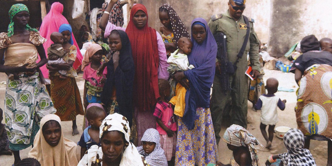 BEST QUALITY AVAILABLEThis handout picture released by the Nigerian army on April 30, 2015 and taken this week in an undisclosed location in the Sambisa Forest, Borno state, purportedly shows a member of the Nigerian Army standing next to a group of women and children rescued in an operation against the Islamist group Boko Haram. Boko Haram hostages were held in atrocious conditions in the group's Sambisa Forest stronghold, Nigeria's military said on April 30 after nearly 500 women and girls were released this week. AFP PHOTO / NIGERIAN ARMY-- RESTRICTED TO EDITORIAL USE - MANDATORY CREDIT 