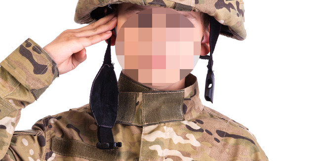 Saluting soldier. Young boy dressed like a soldier isolated on white