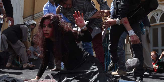 Afghan artists on April 27, 2015 perform a role play to depict the lynching of Afghan woman Farkhunda, 27, who was attacked by an angry mob, in Kabul. Farkhunda was beaten with sticks and stones, thrown from a roof, before being run over by a car outside a mosque in Kabul on March 19. The mob then set her body ablaze and dumped it in a river as police allegedly looked on. AFP PHOTO / SHAH Marai