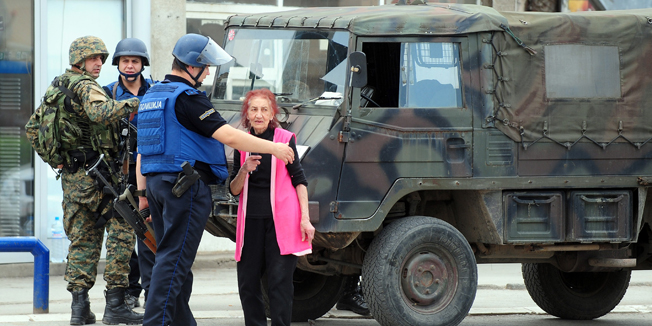 Macedonian police speak with a resident as they patrol in Kumanovo, north of the capital Skopje on May 9, 2015. Heavily armed police entered the outskirts of the north Macedonian town in what a spokesman described as an operation against an 