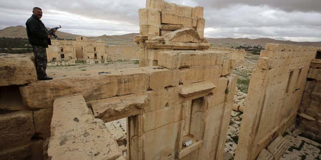 (FILES) - A file picture taken on March 14, 2014 shows a Syrian policeman standing on the sanctury of Baal in the ancient oasis city of Palmyra, 215 kilometres northeast of Damascus. Islamic State (IS) group jihadists, who boast of having destroyed ancient sites in Iraq, threatened the ancient jewel of Palmyra, a UNESCO heritage site in the Syrian desert, on May 14, 2015. AFP PHOTO/JOSEPH EID