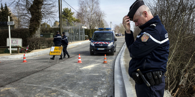 A French gendarme stands as the road is close in Avallon on March 11, 2015 after a group of 