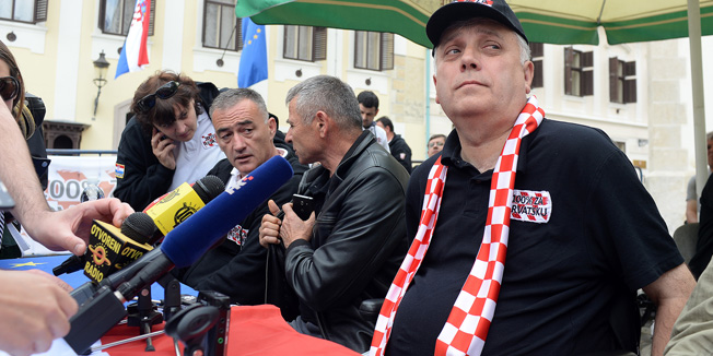 Zagreb, 280515.Markov trg.Nakon sto su se pridruzili prosvjedu Imunoloskog zavoda, branitelji prosvjednici danas su predvodjeni Djurom Glogoskim dosli na Markov trg trazeci sastanak sa premijerom. Na trg su donijeli i suncobrane te se sklonili pod njima.Na fotografiji: Djuro Glogoski, konferencija za medije.Foto: Goran Mehkek / CROPIX