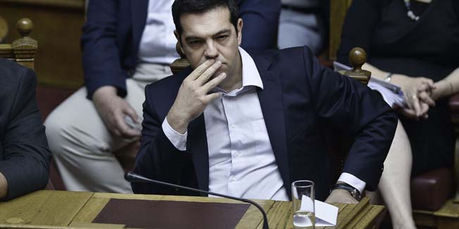 Greek Prime Minister Alexis Tsipras looks on during a parliamentary session in Athens on June 27, 2015. Greece will hold a referendum on July 5 on the outcome of negotiations with its international creditors taking place in Brussels on June 27, Prime Minister Alexis Tsipras announced. AFP PHOTO / ANGELOS TZORTZINIS