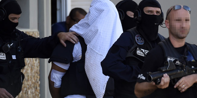 French police escort Yassin Salhi (C), a man suspected of decapitating his boss in an attack on a gas factory, as they leave his flat in Saint-Priest on June 28, 2015. Salhi confessed to the grisly crime, as he was transferred to Paris for questioning by anti-terrorism police. The 35-year-old 