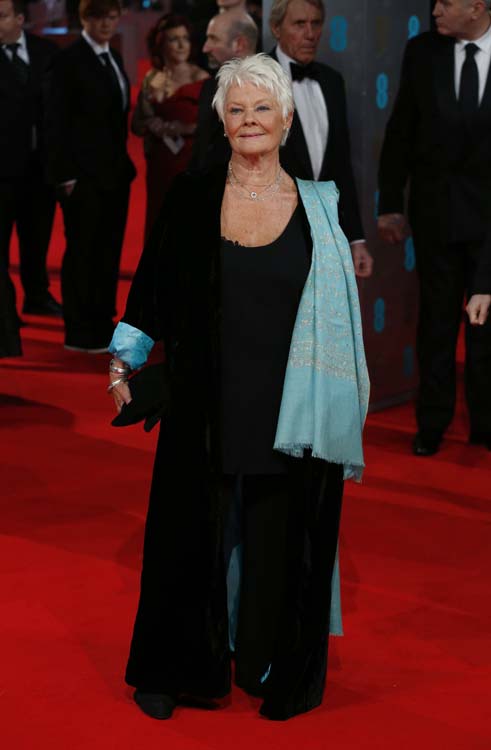 British actress Judi Dench arrives on the red carpet for the BAFTA British Academy Film Awards at the Royal Opera House in London on February 16, 2014. AFP PHOTO / ANDREW COWIE