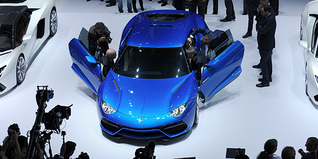 Visitors look at Lamborghini Asterion cars at the Lamborghini stand at the Paris Auto Show on October 2, 2014 on the first of the two press days.  AFP PHOTO / ERIC PIERMONT