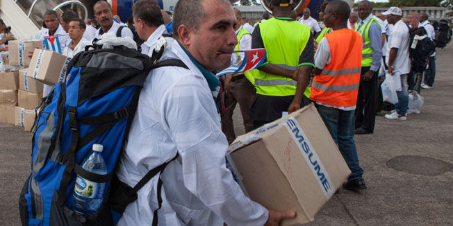 The first members of a team of 165 Cuban doctors and health workers unload boxes of medicines and medical material from a plane upon their arrival at Freetown's airport to help the fight against Ebola in Sierra Leone, on October 2, 2014. AFP PHOTO FLORIAN PLAUCHEUR