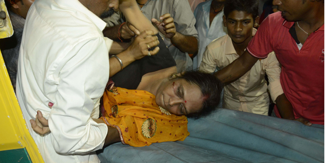 An injured woman is lifted onto a stretcher following a stampede as people celebrated the Dussehra festival, in Patna, in Bihar state, on October 3, 2014. A stampede at the popular religious festival in eastern India left 32 people dead and several dozen injured, an official said. AFP PHOTO/SHABINA ARZOO