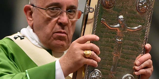 Pope Francis holds the book of the Gospels during a papal mass at St Peter's basilica on October 5, 2014 at the Vatican.   AFP PHOTO / GABRIEL BOUYS