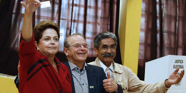 Brazilian President and presidential candidate for the Workers Party, Dilma Rousseff(L) poses with Tarso Genro(C) Governor candidate for Rio Grande do Sul state and one of the PT founders Olivio Dutra(R) at a polling station in Porto Alegre, state of Rio Grande do Sul, Brazil, on October 5, 2014. More than 142 million Brazilians went to the polls Sunday in presidential and legislative elections to cap a dramatic campaign. Leftist incumbent Dilma Rousseff was expected to top the presidential poll but fail to secure the 50 percent necessary to avoid a run-off vote on October 26 against either social democrat Aecio Neves or environmentalist Marina Silva. AFP PHOTO/Lucas UEBEL