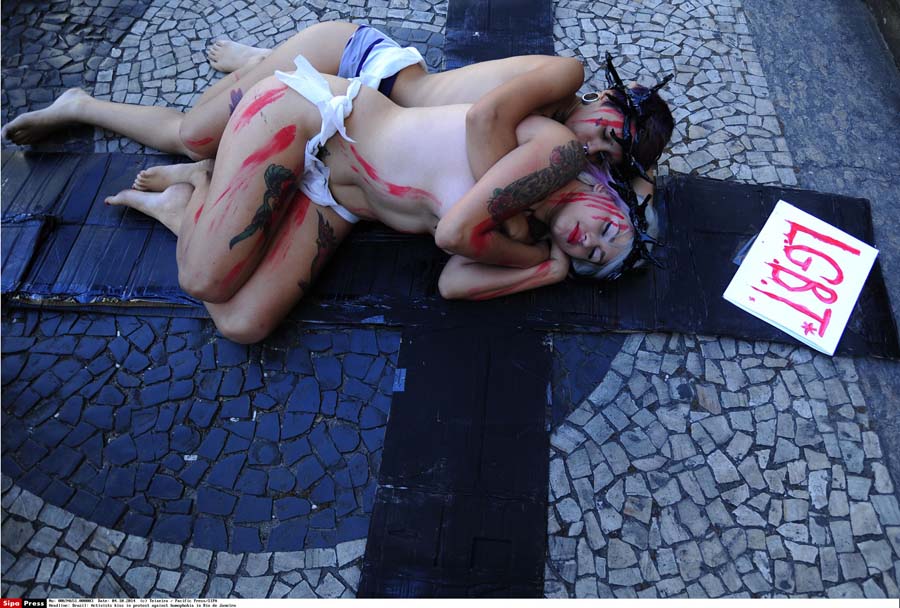 In a protest against homophobia, two scantily clad activists kissed in front of the Candelaria church in a mock crucifixion in downtown Rio on Saturday. The women have painted on their bodies the words 