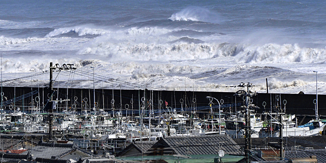 High waves surge toward a port of Kawaminami town in Miyazaki prefecture, Japan's southern island of Kyushu on October 13, 2014, while fishing boats evacuate in the port. Powerful typhoon Vongfong barreled into Japan, with at least one person missing and dozens injured. AFP PHOTO / JIJI PRESS    JAPAN OUT