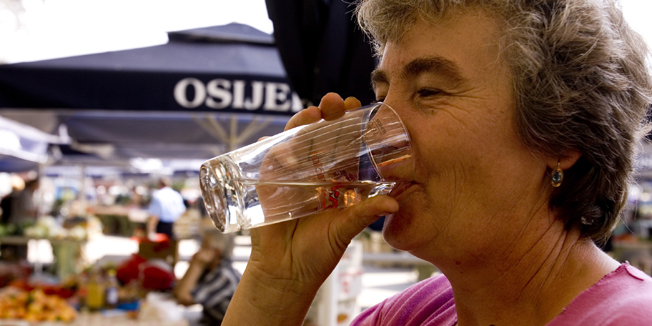 osijek 200707.Prodavacica na osjeckoj trznici osvjezava se casom vode (dravskom) jer je osijek ponovno jedan od najtoplijih gradova u hrvatskoj.Foto : Vlado Kos / CROPIX