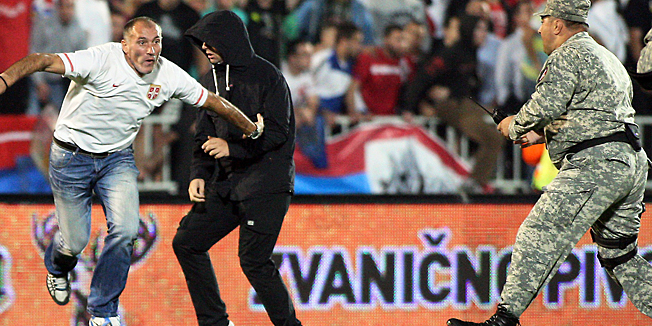Serbian fans invade the pitch after the UEFA Euro 2016 group I qualifying football match between Serbia and Albania in Belgrade was stopped after a flag with Albanian national symbols was flown by a remotely operated drone on October 14, 2014. A Euro 2016 qualifying tie between Serbia and Albania was abandoned after a drone carrying a pro-Albanian message was flown over the stadium, sparking violent scenes on and off the pitch. AFP PHOTO / GENT SHKULLAKU