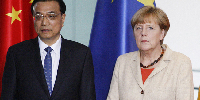 Chinese Prime Minister Li Keqiang (2nd L) and German Chancellor Angela Merkel (2nd R) look on as German Vice Chancellor, Economy and Energy Minister Sigmar Gabriel (R) and Gao Hucheng (L), Chinese Minister of Commerce, sign an agreement on legal and political exchange during a signing ceremony after talks at the Chancellery in Berlin on October 10, 2014. China's Premier Li's 14 ministers met 12 German counterparts to discuss cooperation in fields ranging from climate change and agriculture to using German green-tech to manage China's breakneck economic growth. AFP PHOTO / TOBIAS SCHWARZduring a signing ceremony after talks at the Chancellery in Berlin on October 10, 2014. China's Premier Li's 14 ministers met 12 German counterparts to discuss cooperation in fields ranging from climate change and agriculture to using German green-tech to manage China's breakneck economic growth. AFP PHOTO / ODD ANDERSEN