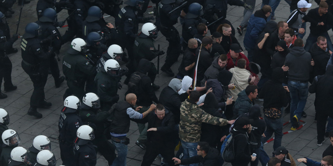 Far-right hooligans clash with police as they protest against Islamist extremism on October 26, 2014 in Cologne. German riot police Sunday clashed with far-right hooligans who rallied against Islamist extremism, with authorities using water cannon and tear gas against the rock-throwing protesters. The banner reads 'Civil courage for Germany'.  AFP PHOTO / DPA /THILO SCHMÜLGEN /GERMANY OUT