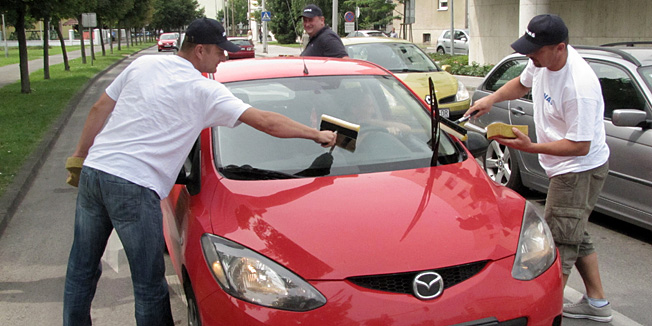 Sisak, 150713.Zaposlenici INE u organizaciji Sindikata INAS odrzali su po gradovima nacionalnu akciju kako bi upozorili gradjane na sustavno pretvaranje INE u MOL-ovu podruznicu. Djelatnici su u Sisku prali vjetrobranska stakla na automobilima i dijelili zvakace, aludirajuci da ce pranje automobila i prodaja zvakaca uskoro biti jedini njihov posao. Na fotografiji: Inini radnici peru stakla automobila.Foto: Mate Piskor / CROPIX                                  