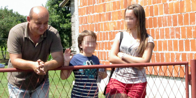 Sisak, 190713.Ovrha koja je trebala biti obavljena nad djecom koja su  odbila otici od oca Ivice Kukuljace, nakon sto je sud donio privremenu mjeru da se djeca dodijele majci, inzistiranjem djece da zele ostati s ocem, odgodjena je do okoncanja sudskog postupka.Na fotografiji: Ivica Kukuljaca, te njegova osmogodisnja i 15-godisnja kci na ulazu u dvoriste njihove obiteljske kuce.Foto: Mate Piskor / CROPIX *** Local Caption ***  