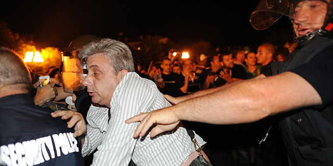 Bulgarian riot policemen push a protestor during an anti-government protest in Sofia on July 23, 2013. Bulgarian protesters clashed with police on the 40th evening of massive anti-government rallies in the EU's poorest country Tuesday after blockading ministers, lawmakers and journalists inside parliament for over five hours.AFP PHOTO / DIMITAR DILKOFF