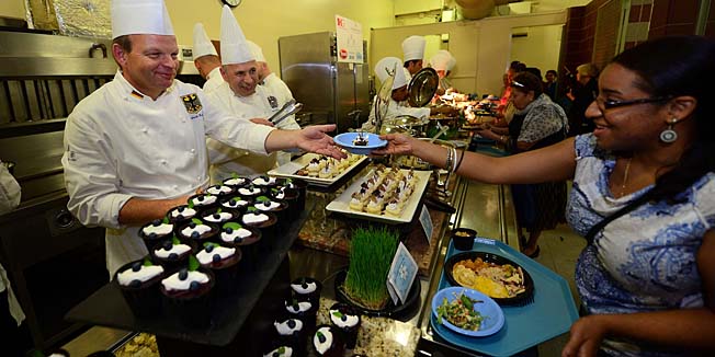 Chefs of world leaders serve dishes they prepared to New York residents in need, at Xavier Mission food pantry in New York, July 27, 2013. Chefs to President Obama, the Queen of England, President of France, King of Sweden, Chancellor of Germany, President of India, King of Thailand, Prince of Monaco, were among the 20 Chefs of World Leaders (Le Club des Chefs des Chefs or C.C.C.) preparing and serving dishes to New Yorkers in need as part of charity drive to help local food banks for poor people. At (L) is Ulrich Kerz, Chef to German Chancellor Angela Merkel. AFP PHOTO/Emmanuel Dunand