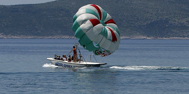 Makarska, 090610Temperatura mora iznad 20 stupnjeva privlaci sve visei turista na Makarsku rivijeru i njene plaze na kojima se lakse podnose ljetnje temperature od vise od 30 celzija u hladuNa slici kupacice na makarskoj plazi i gliser koji dize padobran u daljiniFoto: Ivo Ravlic / CROPIX