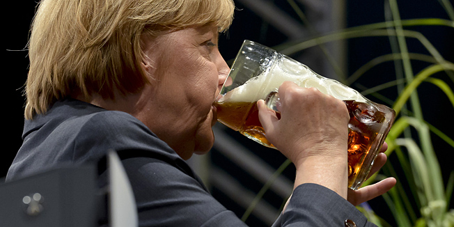 German Chancellor Angela Merkel of the German Christian Democratic Union (CDU) drinks a beer after her speech at a campaign event of the Christian Social Union (CSU) in a beer tent in Dachau, southern Germany on August 20, 2013. Before Merkel became the first German Chancellor to visit the Concentration Camp Memorial in Dachau, but critics slammed her decision to include the stop on an election campaign swing. AFP PHOTO / GUENTER SCHIFFMANN