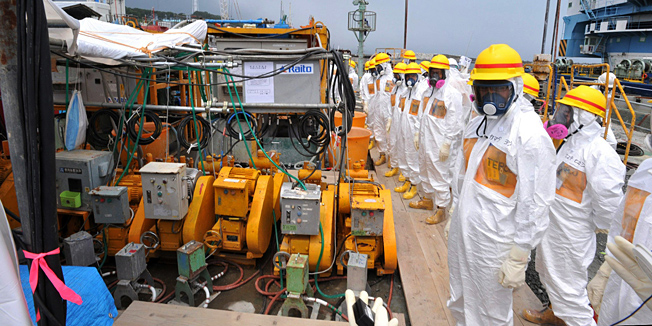 This photo taken on August 6, 2013 shows local government officials and nuclear experts inspecting a facility to prevent seeping of contamination water into the sea at Tokyo Electric Power's (TEPCO) Fukushima Dai-ichi nuclear plant in Okuma, Fukushima prefecture. Japan will accelerate efforts to prevent more radioactive groundwater from seeping into the ocean at the crippled Fukushima nuclear plant, government officials said on August 7, as critics slam its operator's handling of the issue.  JAPAN OUT      AFP PHOTO / JAPAN POOL via JIJI PRESS