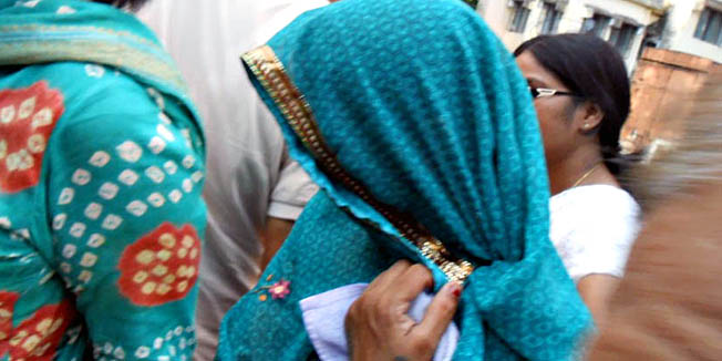Indian school principal Meena Devi (C) arrives to surrender at the district court in Saran district, India's Bihar state, on July 24, 2013. Police July 24 arrested the head of a school in eastern India where 23 children died after eating a free meal laced with a lethal pesticide, an officer said. AFP PHOTO/STR