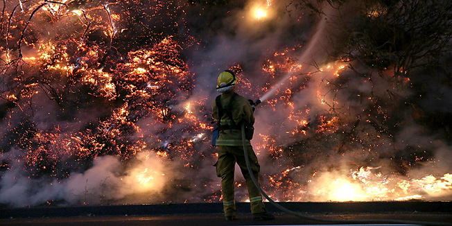 GROVELAND, CA - AUGUST 24: A firefighter uses a hose to douse the flames of the Rim Fire on August 24, 2013 near Groveland, California. The Rim Fire continues to burn out of control and threatens 4,500 homes outside of Yosemite National Park. Over 2,000 firefighters are battling the blaze that has entered a section of Yosemite National Park and is currently 5 percent contained.   Justin Sullivan/Getty Images/AFP== FOR NEWSPAPERS, INTERNET, TELCOS & TELEVISION USE ONLY ==