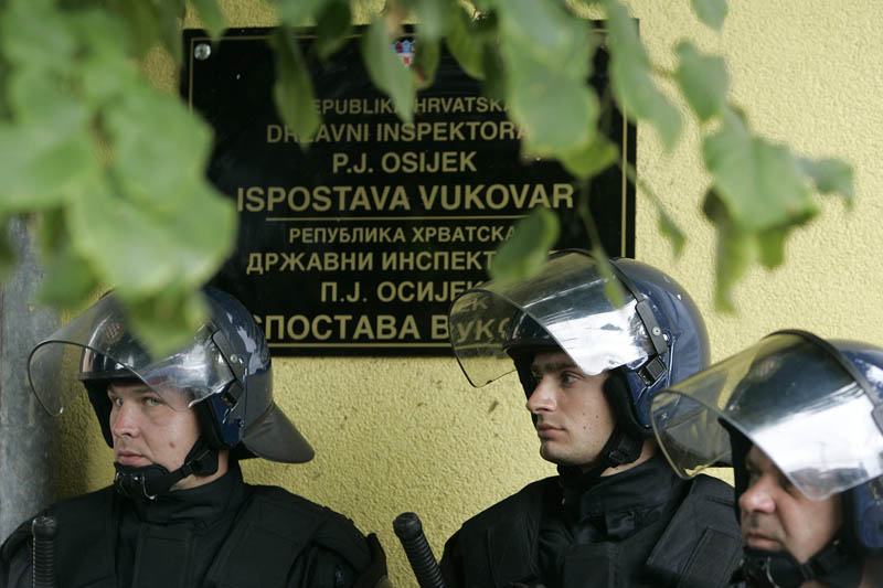 Vukovar, 030913.Tristotinjak prosvjednika mirno je proslo u koloni Vukovarom na kratko se zaustavljajuci  ispred zgrada na koje su postavljeni dvojezicni natpisi.Zgrade cuva interventna policija pod punom opremom.Izgreda za vrijeme mimohoda nije bilo.Na fotografiji: interventna policija cuvaa zgradu Drzavnog inspektoraka na kojoj je  postavljena ploca s dvojezicnim natpisom.Foto: Vlado Kos / Cropix  