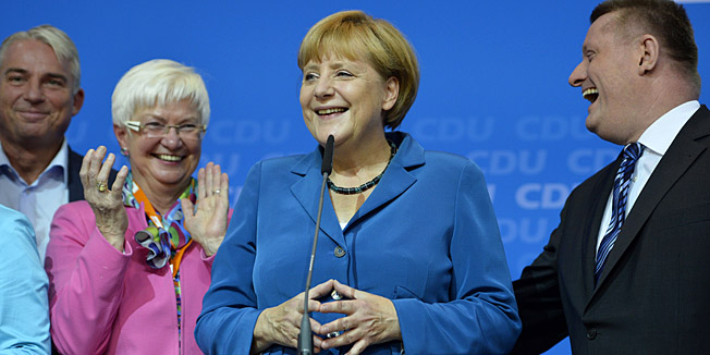 German Chancellor and candidate for the Christian Democratic Union (CDU) Angela Merkel (C) addresses supporters after exit polls were broadcast on television in Berlin on September 22, 2013, after the German general elections. Chancellor Angela Merkel clinched a third term in German elections Sunday but will be forced to form an awkward coalition with her chief rivals to govern Europe's top economy, exit polls indicated. AFP PHOTO ? ODD ANDERSEN