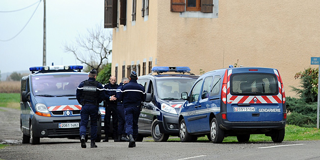 French Gendarmes patrol, on November 15, 2013 in the southern town of Noulhian, in front of the house where a farmer was killed overnight. A young homeless man who claimed he heard voices killed a 90-year-old villager and then ate his tongue and heart  and burnt the body, officials said. Prior to his arrest, the youth also attacked another man, hitting him against a tractor in the village, located near the border with Spain. AFP PHOTO / REMY GABALDA