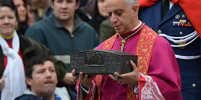 Italian archbishop Rino Fisichella holds the ashes of St Peter before a ceremony of Solemnity of Our Lord Jesus Christ the King at St Peter's square on November 24, 2013 at the Vatican.  AFP PHOTO / VINCENZO PINTO