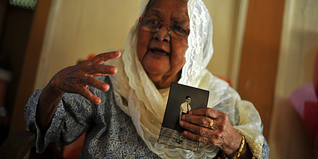 Hasnah Abdul Wahab holds an old portrait of her younger sister, Siti Aishah Abdul Wahab, during an interview with Agence France-Presse at her house in Jelebu, a district of Negeri Sembilan, outside Kuala Lumpur on November 27, 2013. Police in Kuala Lumpur said on November 27 one of three women allegedly held as slaves in London for 30 years was a Malaysian who went missing in the 1960s, prompting a joyous reaction from the long-lost woman's sister.      AFP PHOTO / MOHD RASFAN