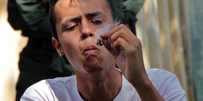 A man smokes marijuana during a demo for its legalization in Medellin, Colombia on May 7, 2011. Hundreds of youngsters marched in several events throughout Latin America, under the slogan 